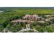 Aerial view of a multi-story condo surrounded by lush greenery and serene bodies of water at 502 Mirasol Cir # 103, Kissimmee, FL 34747