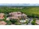 Wide aerial view of a multi-story condo with a pool, parking, and lush landscaping at 502 Mirasol Cir # 103, Kissimmee, FL 34747