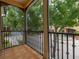 Balcony with tile flooring and ornate railings overlooking lush trees and the neighborhood courtyard at 502 Mirasol Cir # 103, Kissimmee, FL 34747