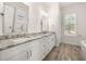 An elegant bathroom featuring double sinks with light marble countertops and wood-look flooring at 502 Mirasol Cir # 103, Kissimmee, FL 34747