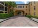 Driveway to condominium complex with arched entry and manicured shrubbery on either side at 502 Mirasol Cir # 103, Kissimmee, FL 34747