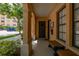 Charming covered porch with an elegant entrance door, bench, and lush landscaping creating an inviting welcome at 502 Mirasol Cir # 103, Kissimmee, FL 34747