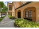 Inviting home exterior with arched doorway, dark wooden door, bench, and neatly manicured shrubs at 502 Mirasol Cir # 103, Kissimmee, FL 34747