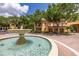 Charming tan two-story home with a water fountain and mature trees adding to the beautiful neighborhood aesthetic at 502 Mirasol Cir # 103, Kissimmee, FL 34747