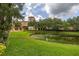 Scenic view of a meticulously manicured lawn with a calm pond in front of a condo complex at 502 Mirasol Cir # 103, Kissimmee, FL 34747