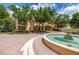 Picturesque tan two-story home with a water fountain and mature trees adding to the beautiful neighborhood aesthetic at 502 Mirasol Cir # 103, Kissimmee, FL 34747