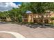 Attractive tan two-story home with trees shading the brick walkway and beautiful landscaping around the building at 502 Mirasol Cir # 103, Kissimmee, FL 34747