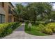 Condominium complex with sidewalk, greenery and mature trees near lake at 502 Mirasol Cir # 103, Kissimmee, FL 34747