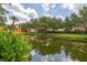 Reflective view of a condo complex in a calm pond surrounded by tropical vegetation at 502 Mirasol Cir # 103, Kissimmee, FL 34747