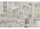 Bright kitchen features a farmhouse sink, stainless steel appliances, granite counters, and white cabinets at 502 Mirasol Cir # 103, Kissimmee, FL 34747