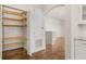 View of an open pantry with wood shelving and access to the hardwood floors at 502 Mirasol Cir # 103, Kissimmee, FL 34747