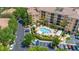 Aerial view of the community pool, showcasing lounge chairs, cabanas, lush landscaping, and reserved parking at 502 Mirasol Cir # 103, Kissimmee, FL 34747