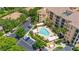 Aerial view of the community pool, showcasing lounge chairs, cabanas, lush landscaping, and reserved parking at 502 Mirasol Cir # 103, Kissimmee, FL 34747
