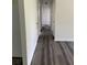 Long hallway featuring freshly painted walls, white doors, and dark laminate flooring at 5449 Nw 2Nd St, Ocala, FL 34482
