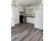Clean kitchen with white cabinetry, stainless steel appliances, light countertops and dark laminate flooring at 5449 Nw 2Nd St, Ocala, FL 34482