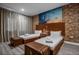 Stylish bedroom with industrial brick accent wall, modern decor, and cozy twin beds at 5573 Torino Rd, Kissimmee, FL 34746