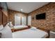 Bright bedroom showcases a brick accent wall, twin beds, and minimalist decor at 5573 Torino Rd, Kissimmee, FL 34746