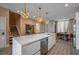 Bright kitchen with a large island and pendant lights offers a modern design with a view into the dining area at 5573 Torino Rd, Kissimmee, FL 34746