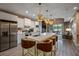 Open kitchen with white cabinets, a large island with seating, and stainless steel appliances offers a contemporary design at 5573 Torino Rd, Kissimmee, FL 34746