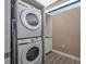 Convenient laundry area equipped with a stacked washer and dryer, plus extra shelving at 5573 Torino Rd, Kissimmee, FL 34746
