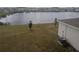 Elevated backyard view featuring a serene pond, mature landscaping, and nearby residences at 5793 Gingham Dr, Kissimmee, FL 34758