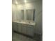 Bathroom with double sink vanity, modern fixtures, and stone countertop at 5793 Gingham Dr, Kissimmee, FL 34758