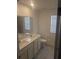 Bathroom featuring a double sink vanity, modern fixtures, large mirrors, and plenty of natural light at 5793 Gingham Dr, Kissimmee, FL 34758
