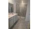 Bathroom featuring glass shower, neutral vanity, and modern tiling at 5793 Gingham Dr, Kissimmee, FL 34758