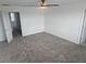 Spacious bedroom with neutral carpet, ceiling fan, and natural lighting at 5793 Gingham Dr, Kissimmee, FL 34758