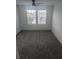 A carpeted bedroom with neutral walls contains a ceiling fan and two large windows with blinds at 5793 Gingham Dr, Kissimmee, FL 34758