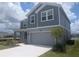 Charming two-story home boasts a two-car garage and manicured front lawn with tasteful landscaping at 5793 Gingham Dr, Kissimmee, FL 34758