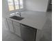 Open kitchen island with stainless steel dishwasher, sink, and stone countertops at 5793 Gingham Dr, Kissimmee, FL 34758