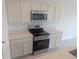Modern kitchen features stainless steel appliances, white cabinets, and stone countertops at 5793 Gingham Dr, Kissimmee, FL 34758