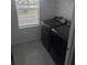 A laundry room with gray tile flooring containing a washer and dryer combo next to a window at 5793 Gingham Dr, Kissimmee, FL 34758