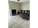 A cozy living room featuring tile flooring, a fireplace, and a comfortable leather sofa with decorative pillows at 5861 La Costa Dr # 115, Orlando, FL 32807