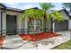 Beautiful single-story home with mature palm trees, grey walls, black trim, and covered front entrance at 6528 Shepherd Oaks Pass, Lakeland, FL 33811