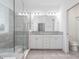Modern bathroom with double vanity, glass shower, and neutral tile, creating a serene space at 7266 Desert Mandarin St, Winter Garden, FL 34787
