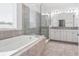Luxurious bathroom featuring a glass-enclosed shower, soaking tub, and double vanity at 7266 Desert Mandarin St, Winter Garden, FL 34787