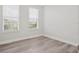 Light-filled bedroom featuring wood-look floors, neutral walls, and bright windows for natural light at 7266 Desert Mandarin St, Winter Garden, FL 34787