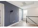 Upstairs hallway with stylish blue accent wall, white trim, and wood-look flooring at 7266 Desert Mandarin St, Winter Garden, FL 34787