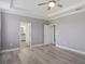 Large main bedroom featuring wood floors, tray ceiling, and access to the ensuite bathroom at 7266 Desert Mandarin St, Winter Garden, FL 34787