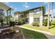 Condo building with lush landscaping, green paint, and stairs at 840 Center Ave # 80, Daytona Beach, FL 32117