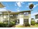 Green and white condo with wooden staircase and mature plants at 840 Center Ave # 80, Daytona Beach, FL 32117