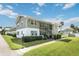 Two-story condo with manicured lawn, white picket fence, and exterior staircase at 840 Center Ave # 80, Daytona Beach, FL 32117
