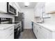 Bright kitchen featuring stainless steel appliances, white cabinets, and new vinyl flooring at 840 Center Ave # 80, Daytona Beach, FL 32117