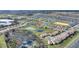 Wide aerial view of the community with houses surrounding a tranquil lake and a golf course in the distance at 8990 Ace Loop, Champions Gate, FL 33896