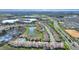 Expansive aerial view of a community featuring homes near lakes, with lush green landscapes, and manicured streets at 8990 Ace Loop, Champions Gate, FL 33896
