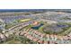 Aerial shot of a residential community showcasing houses, a serene lake, and a well-manicured street layout at 8990 Ace Loop, Champions Gate, FL 33896