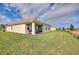 Charming home featuring a covered patio with grill overlooking a well-manicured lawn at 8990 Ace Loop, Champions Gate, FL 33896