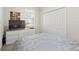 This bedroom has a white closet, white dresser, and neutral color scheme with a window at 8990 Ace Loop, Champions Gate, FL 33896